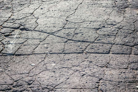 Cracked asphalt surface of the old road.の写真素材
