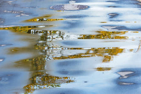 Wet asphalt road surface at autumn evening time.の写真素材