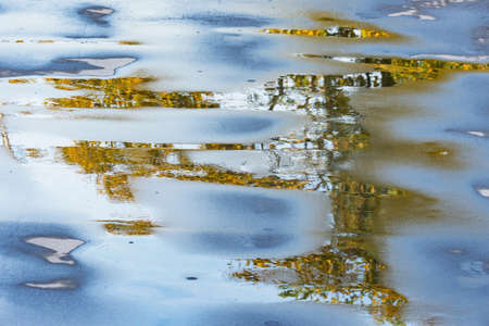 Wet asphalt road surface at autumn evening time.の写真素材