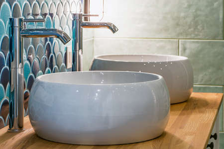 White sinks by the mirror in the bathroom.の写真素材