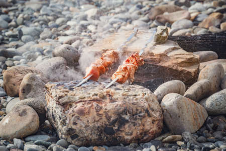 Cooking of the barbecue and sausages on the beach at evening time.の写真素材