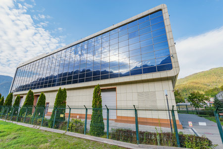 Sochi, Russia - October 18, 2020: Reflection of Caucasus mountains in PAO Rosseti building. PAO Rosseti is a Russian power company, comprising interregional and regional distribution grid companies.のeditorial素材