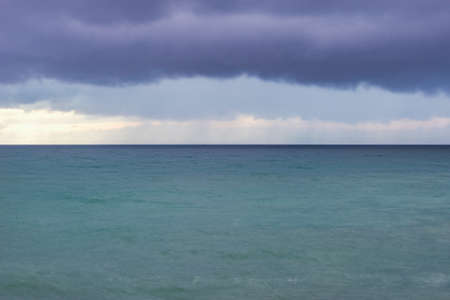 Stormy skies above the sea at sunset time.の写真素材