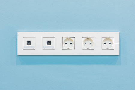 Power socket and Internet socket on blue wall background.の写真素材