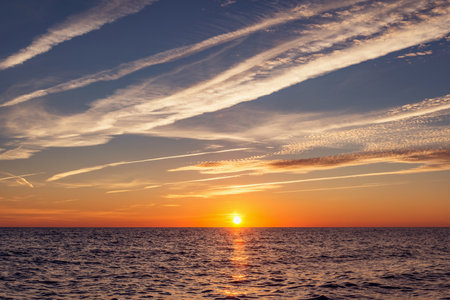 Sunset sky over the calm surface of the sea.の写真素材