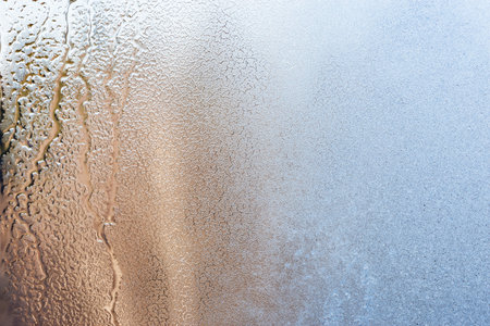 Melting of the ice on the window glass surface.の写真素材