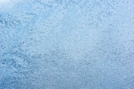 Ice patterns on the window at cold winter day.の写真素材