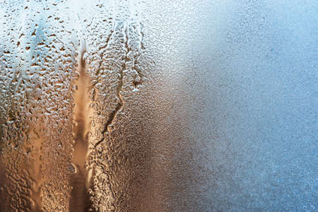 Melting of the ice on the window glass surface.の写真素材
