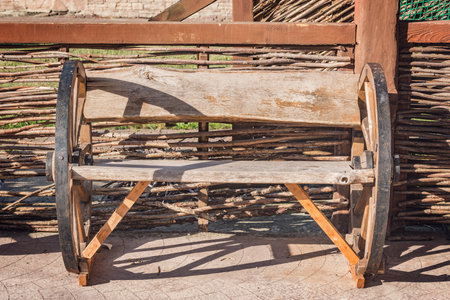 Wooden retro bench by the wooden fence.の写真素材