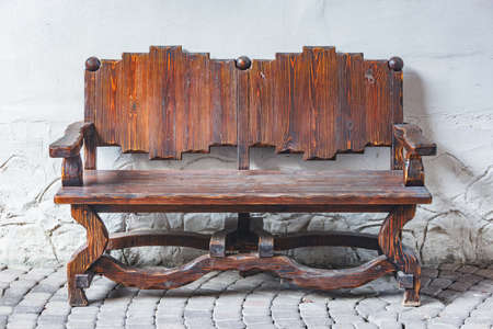 Wooden retro bench by the stone wall.の写真素材