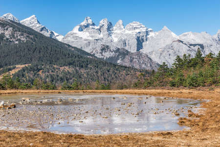 Small frozen lake in the mountains by Lijiang. Yunnan province. China.の写真素材