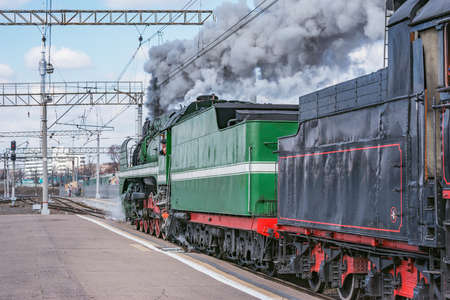 Steam retro train departs from the station.の写真素材