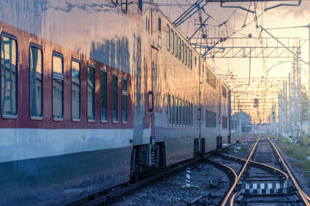 Passenger double deck train departs at sunset.の写真素材