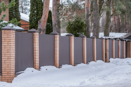 Metal fence by the private house at winter time.の写真素材