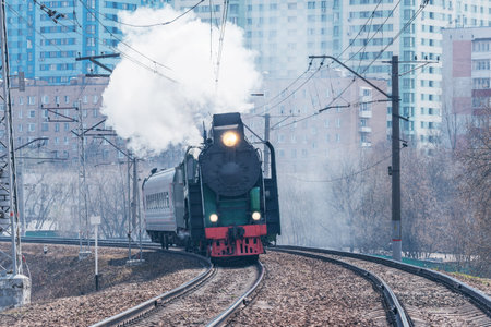 Retro steam train moves on the city background.の写真素材