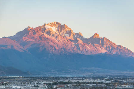Jade Dragon Snow Mountain by the city at sunrise. Lijiang. China.の写真素材