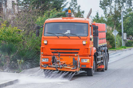 Cleaning machine washes the city street early in the morning.の写真素材