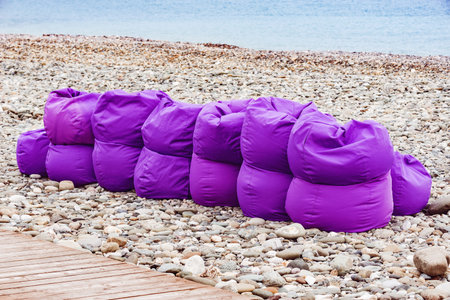 Violet bags for sitting on the sea shore at cold day time.の写真素材