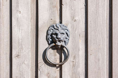 Metal door knocker on wooden door background.の写真素材