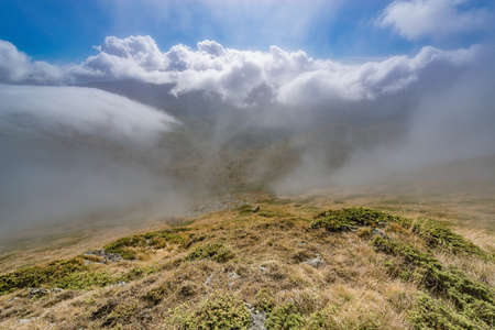 Clouds above the mountains at autumn day time.の写真素材