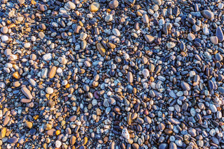 Small stones on the beach at sunset time.の写真素材