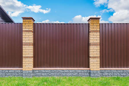 Brown metal fence around the big luxury house.の写真素材