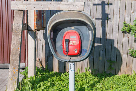 Gray old telephone box on the village street.の写真素材