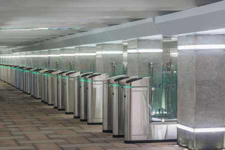 Turnstiles with electronic card readers on the station platform.の写真素材