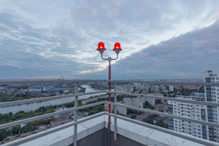 Red warning lights barrage on the city view background at sunset.