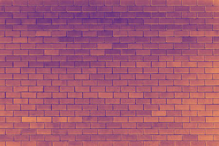 Purple and orange brick wall background at halloween evening.