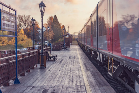 Sortavala Centre, Russia - October 04, 2021: Passenger train stands by the wooden platform at sunset before departure.のeditorial素材