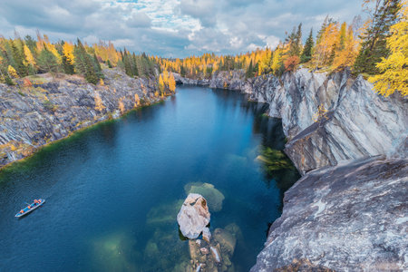 Boat with tourists on the deep marble canyon lake surface. Ruskeala Mountain Park. Republic of Karelia. Russia.の写真素材