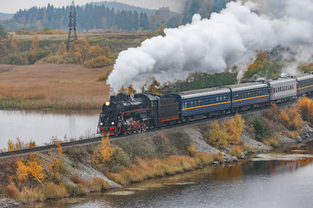 Retro steam train moves along the lake at autumn cloudy time. Karelia. Russia.の写真素材