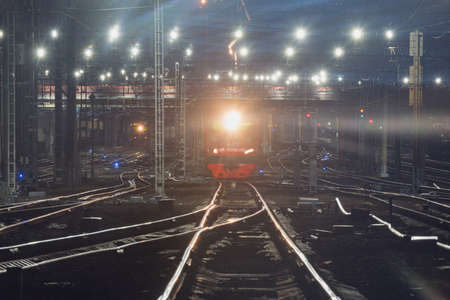 Passenger train moves fast at night time. railway station.の写真素材