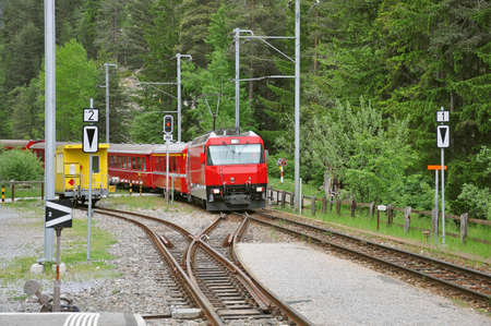 Passenger train arrives to the platform. Swiss Alps.の写真素材