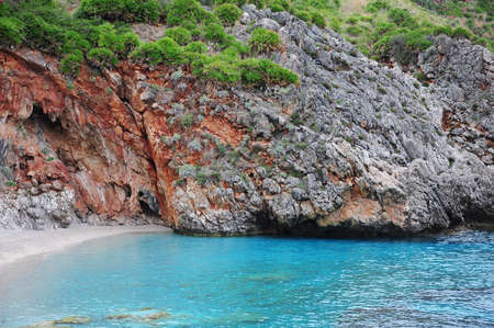 Colorful cliffs by the water edge. Natural reserve Zingaro. Sicily. Italy.の写真素材