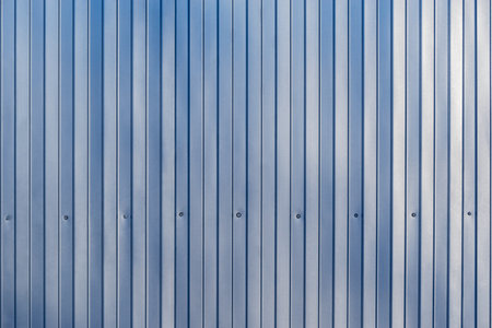 White and blue corrugated metal fence background.の写真素材
