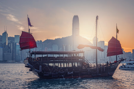 Hong Kong - December 09, 2016: Retro small ship in Hong Kong harbor at sunset time.のeditorial素材