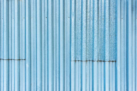 White and blue corrugated metal fence background.の写真素材