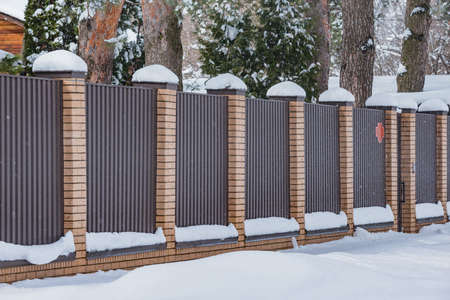 Metal fence by the private house at winter time.の写真素材