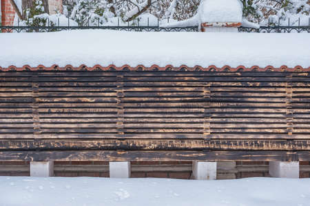 Metal and wooden fence by the private house at winter time.の写真素材
