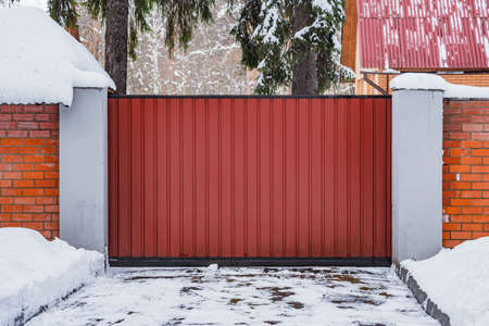 Metal fence by the private house at winter time.の写真素材