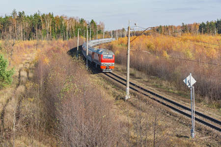Passenger train moves at autumn morning time.の写真素材