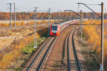 Passenger train moves at autumn morning time.の写真素材