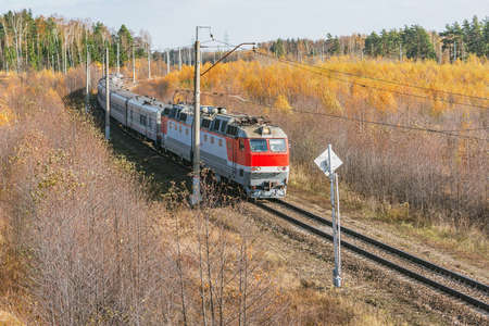 Passenger train moves at autumn morning time.の写真素材