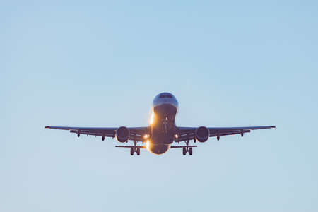 Landing of the passenger plane at sunset time.の写真素材