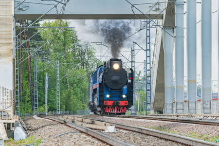 Retro steam train moves through the bridge.