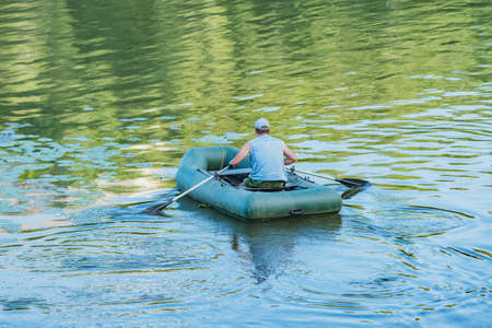 Man floats by inflatable boat on the river.の写真素材