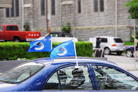 Vancouver, Canada - June 17, 2011: Vancouver Canucks professional ice hockey team flags on the top of the car.のeditorial素材