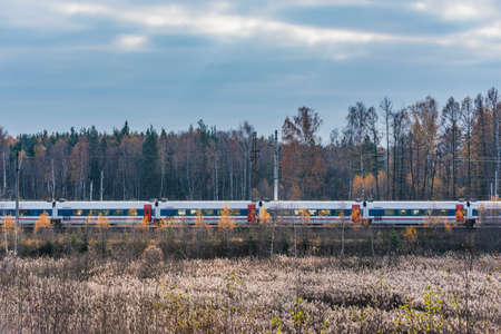 Passenger train moves at autumn morning time.の写真素材